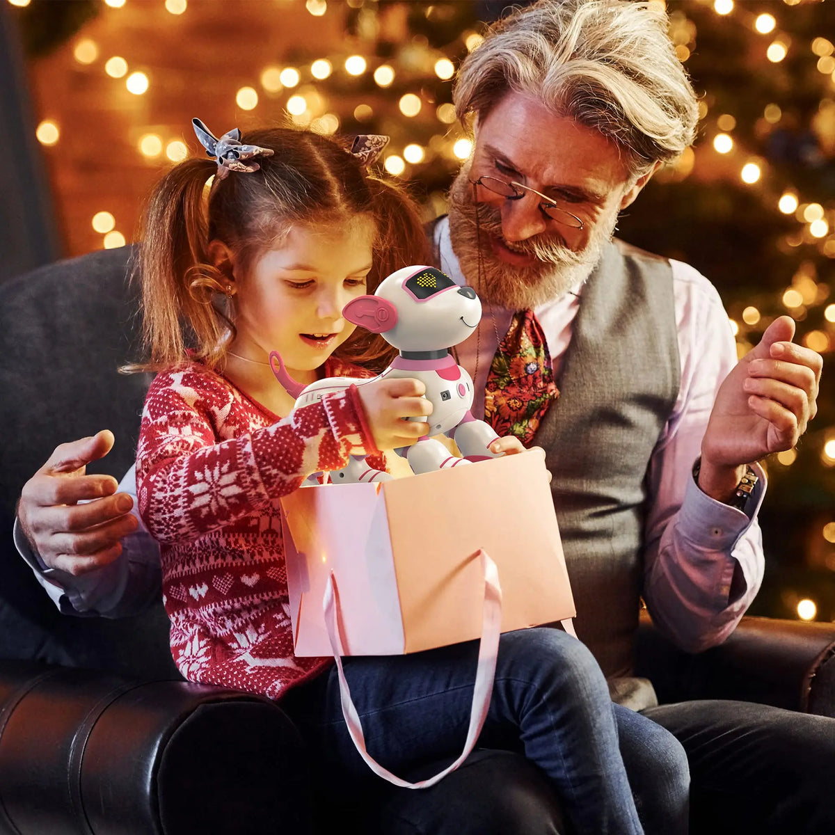 Man and young girl opening a gift together with a toy dog inside, Christmas lights in the background