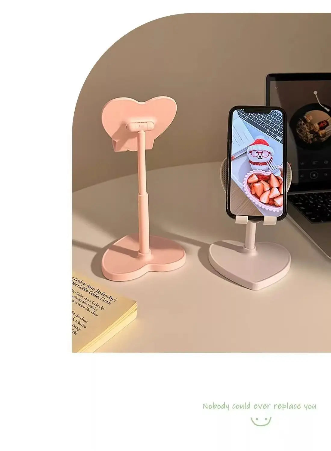 Two phone stands, one pink and one white, on a surface with a phone displaying a Santa Claus image.