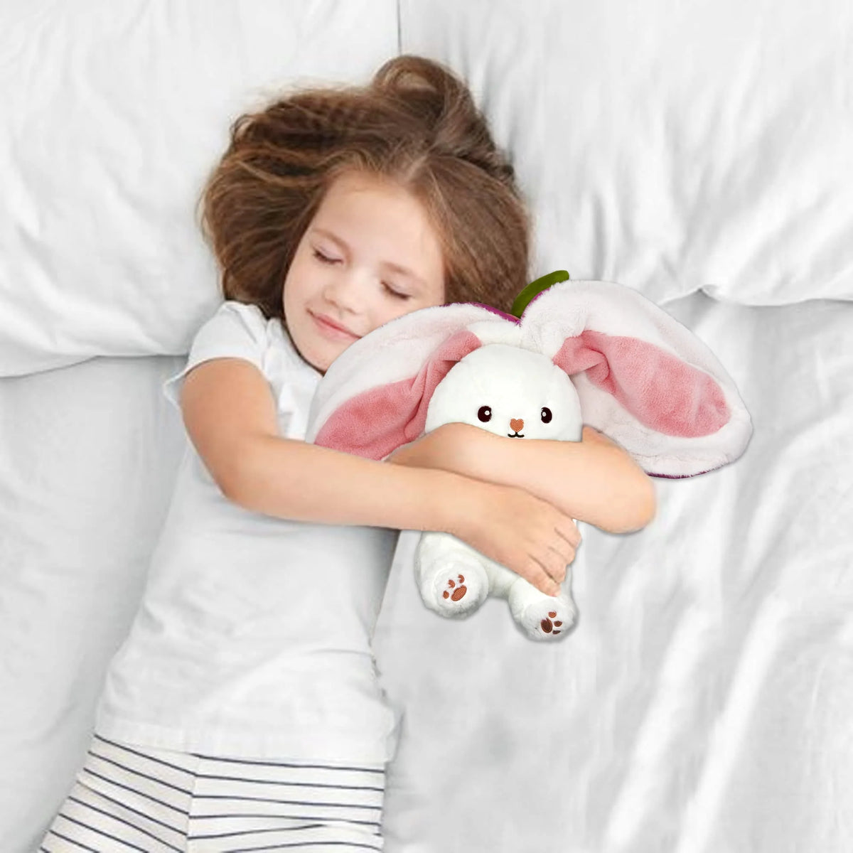 Child sleeping with a plush bunny toy in bed