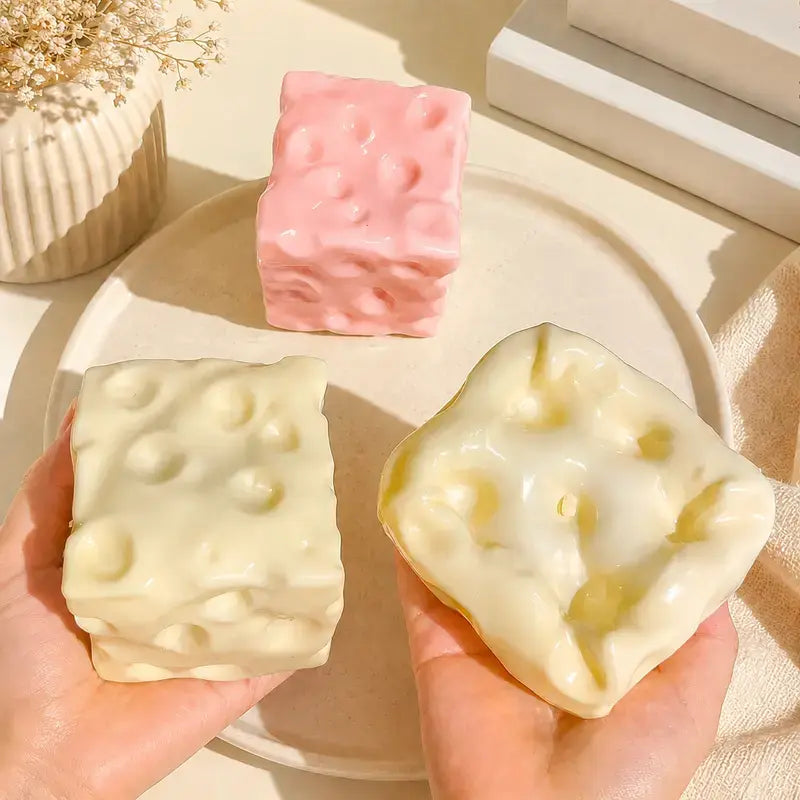 Hand squeezing cheese squishy showing non-rebound texture