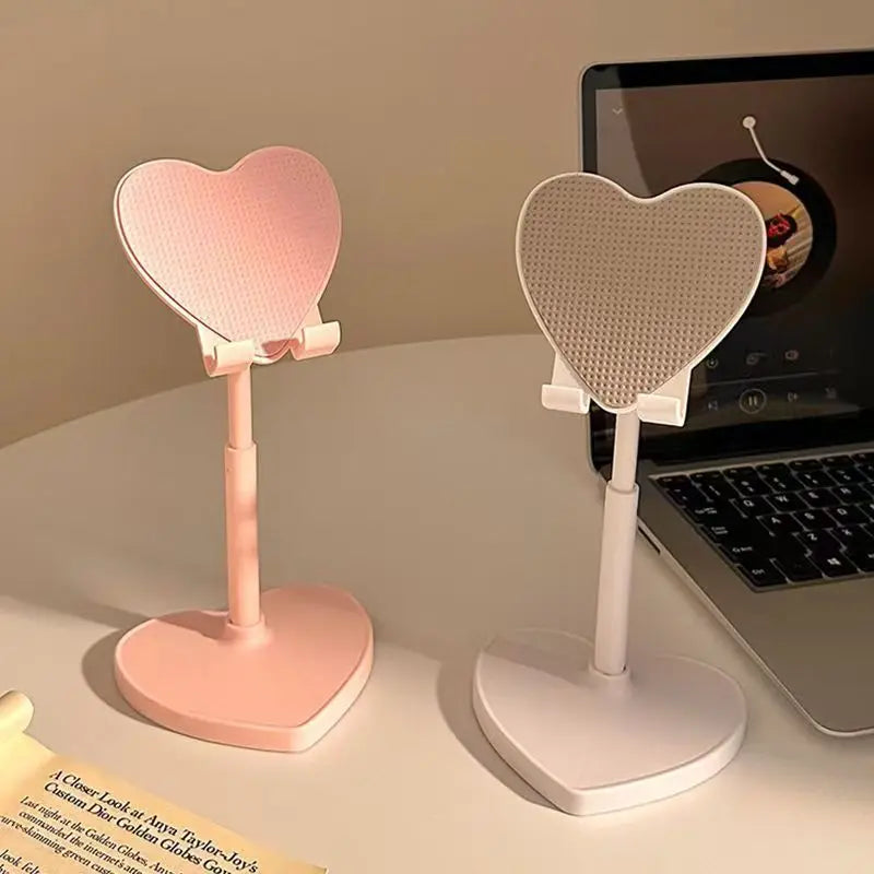 Two heart-shaped desk lamps on a surface with a laptop in the background.