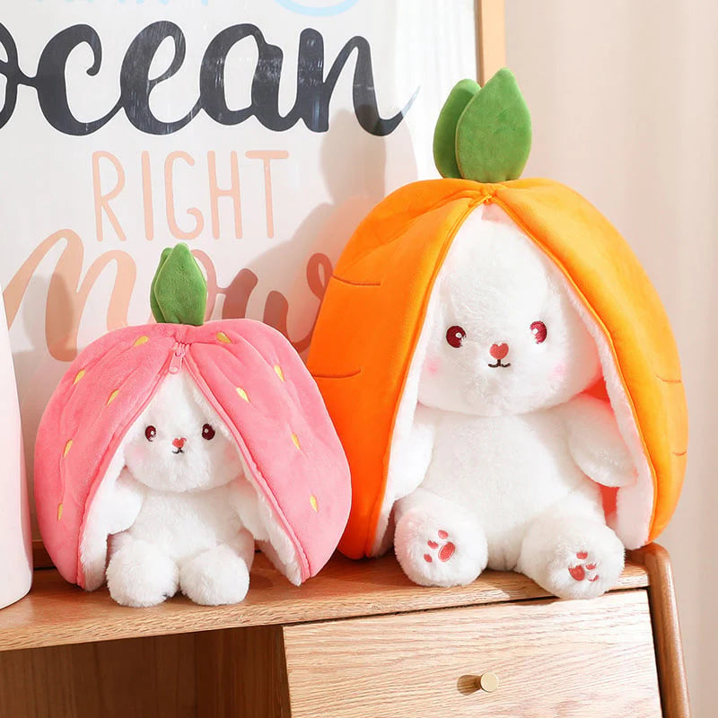 Two plush toys resembling bunnies inside fruit-shaped houses on a wooden surface.