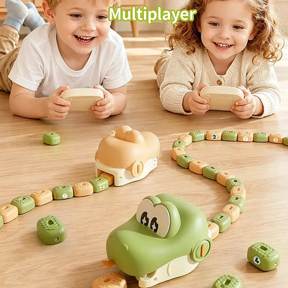 Two young children lying on a wooden floor playing with a colorful Rc greedy snake game. The game features cartoon animal snake, number blocks, and a winding path, with the text 'Multiplayer' at the top.
